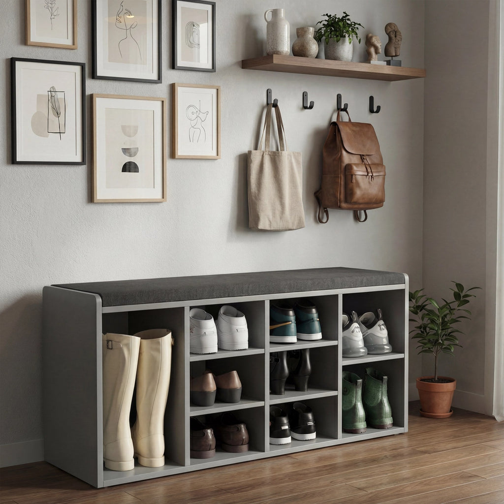 [White] Shoe storage bench at foot of grey upholstered bed with woven baskets and folded linens in cubbies