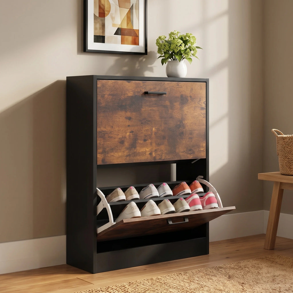 [White] two-tier shoe organizer with pull-out shoe racks, shown in a styled room setting with a beige wall, wooden floor, and a small plant on top.